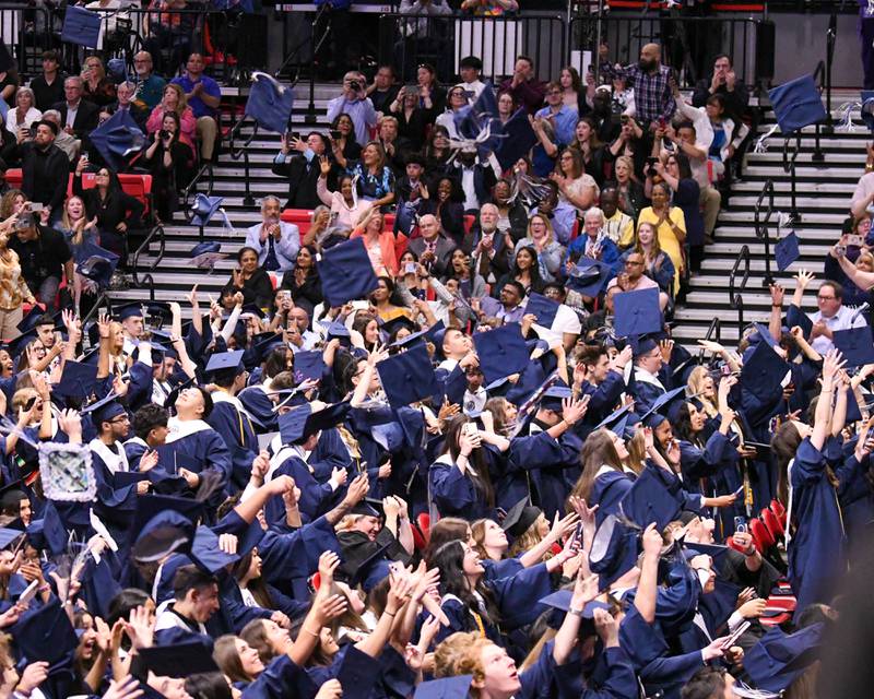 Caps fly in the air after the Oswego East’s graduation commencement ceremony was completed on Saturday May 17, 2025, held at the Convocation Center in DeKalb.