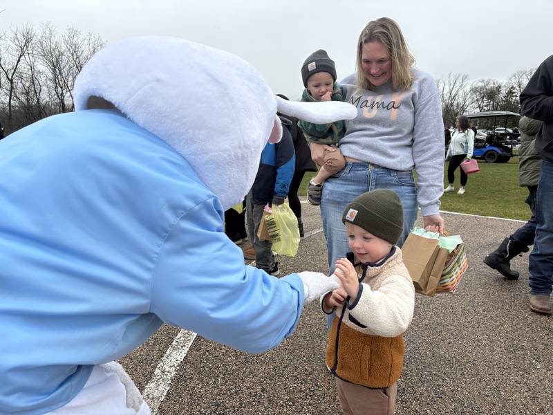 The Easter Bunny visits with Rory Sweno, right, 2, of Richmond, before the Easter Egg Hunt at Sunnyside Memorial Park in Johnsburg, Saturday, April 4, 2026, while Emmett Sweno, 2, of Richmond and Liz Sweno look on.