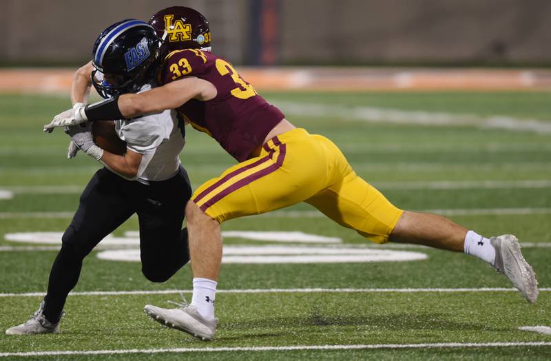 Lincoln-Way East's Cade Serauskis, left, gets tackled by Loyola Academy's Johnny McGuire during the Class 8A football state title game at Memorial Stadium in Champaign on Saturday, Nov. 26, 2022.
