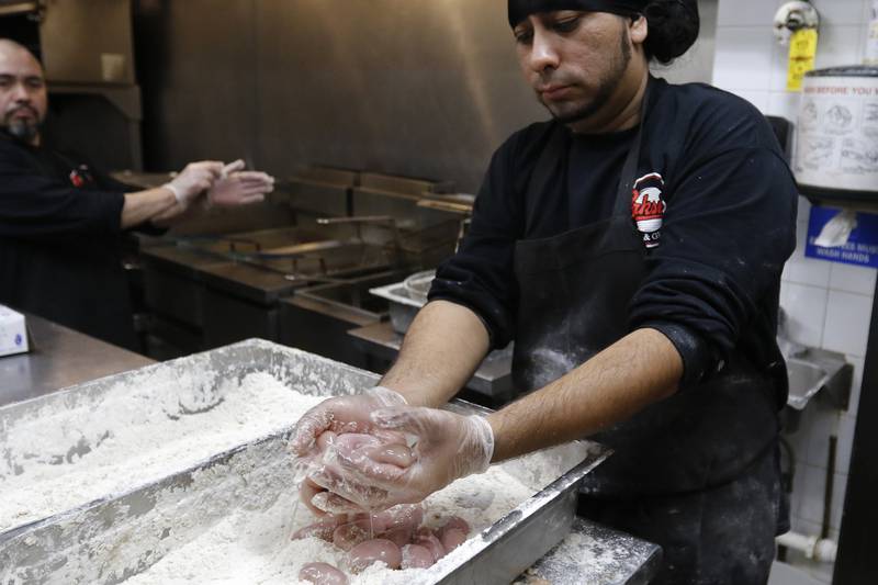 Parkside Pub cook Alfredo Andrado, right, prepares a handful of turkey testicles to be coated in flour prior to deep frying with head cook Javy Garcia during the 39th annual Turkey Testicle Festival at Parkside Pub on Wednesday, Nov. 24, 2021, in Huntley.