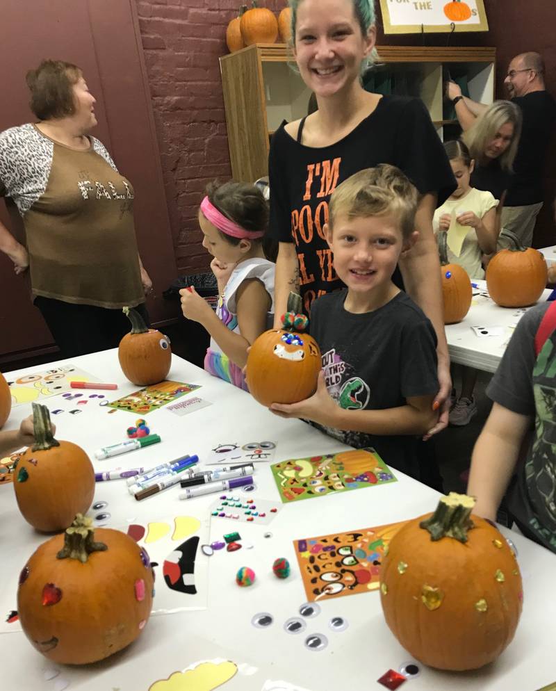 Alex Hulbert, a mother and teacher's assistant, with her son, Killian, have fun decorating his pumpkin at the Seattle Sutton Marseilles Museum.