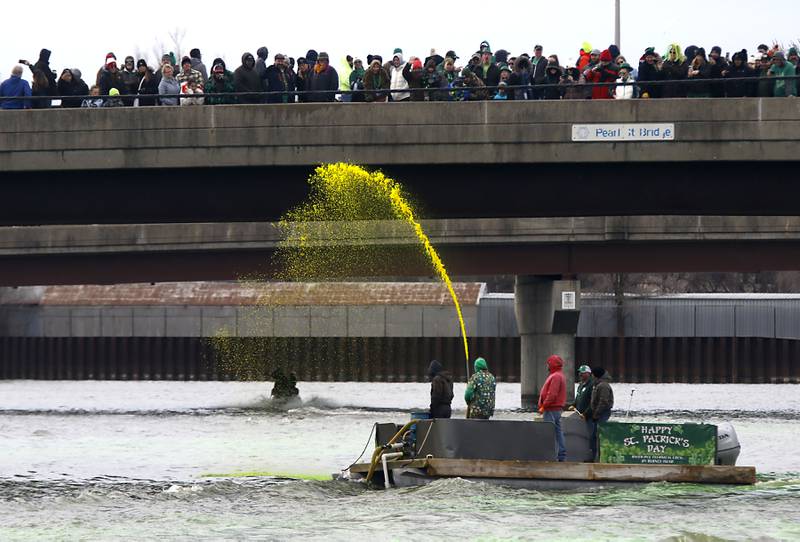 People watch from the bridge as dye is sprayed into the Fox River to dye the river green during the McHenry’s ShamROCKS the Fox Festival on Saturday, March 14, 2026, in McHenry.
