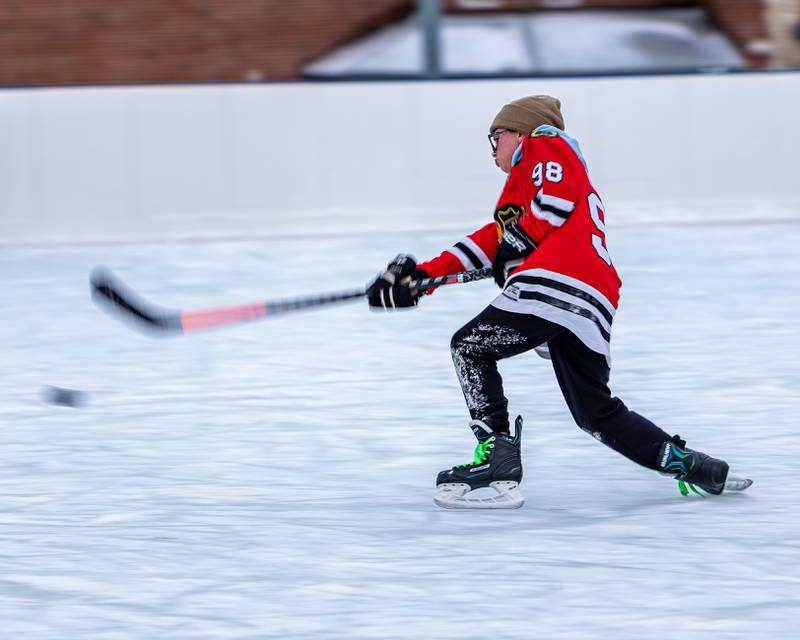 Weston Harris shoots puck towards goal whilst iceskating at Schweickert Arena's Ice Rink on Tuesday, December 30, 2025, at Washington Park in Peru.