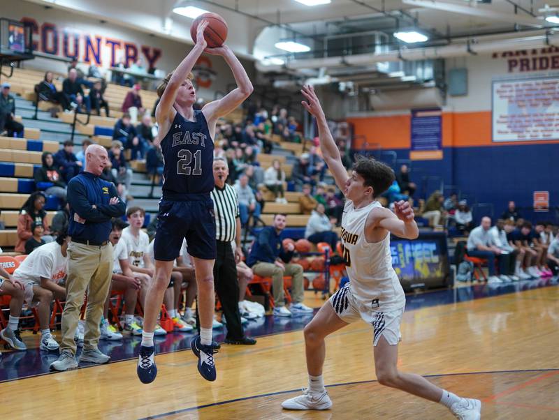 Oswego East's Andrew Pohlman (21) shoots a three pointer against Neuqua Valley during a hoops for healing basketball tournament game at Oswego High School on Friday, Nov 24, 2023.