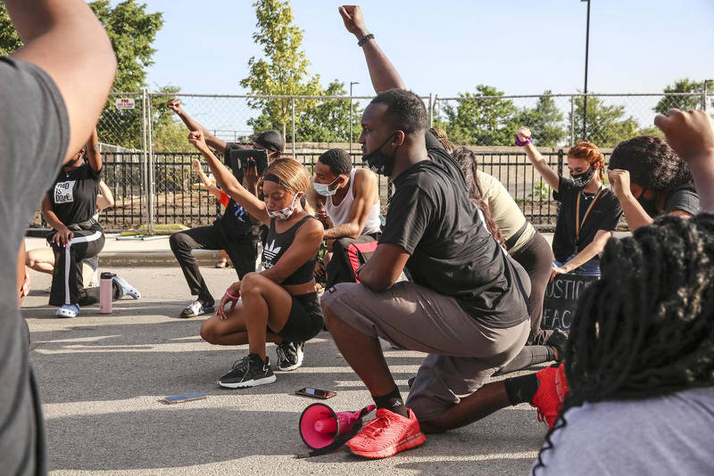 Demonstrators can be seen taking a knee during a moment of silence outside the Will County Courthouse on Saturday, Aug. 22, 2020, in response to the January 28 overdose death of Eric Lurry who died in police custody.