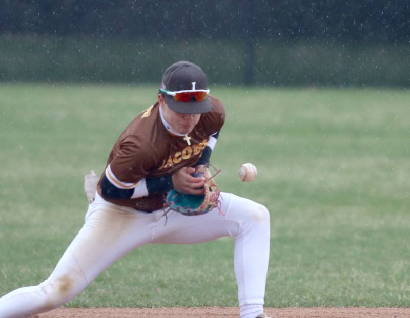 Jacobs’ third baseman Ryan Tucker tries to get a handle on a ground ball as rain falls against Prairie Ridge in varsity baseball on Wednesday, April 9, 2025, at Prairie Ridge High School in Crystal Lake. The game was eventually suspended due to rain.