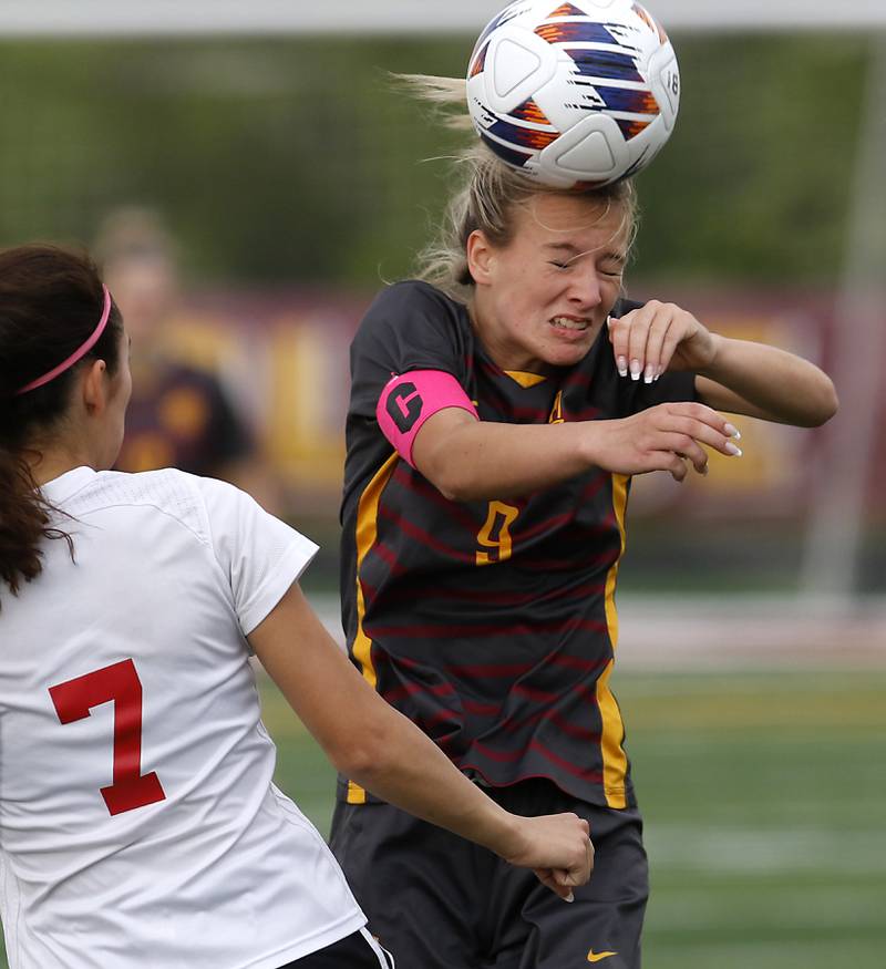 Richmond-Burton's Reese Frericks heads the ball in front of Woodlands Academy’s Maddie Montez during a IHSA Division 1 Richmond-Burton Sectional semifinal soccer match Tuesday, May 16, 2023, at Richmond-Burton High School.