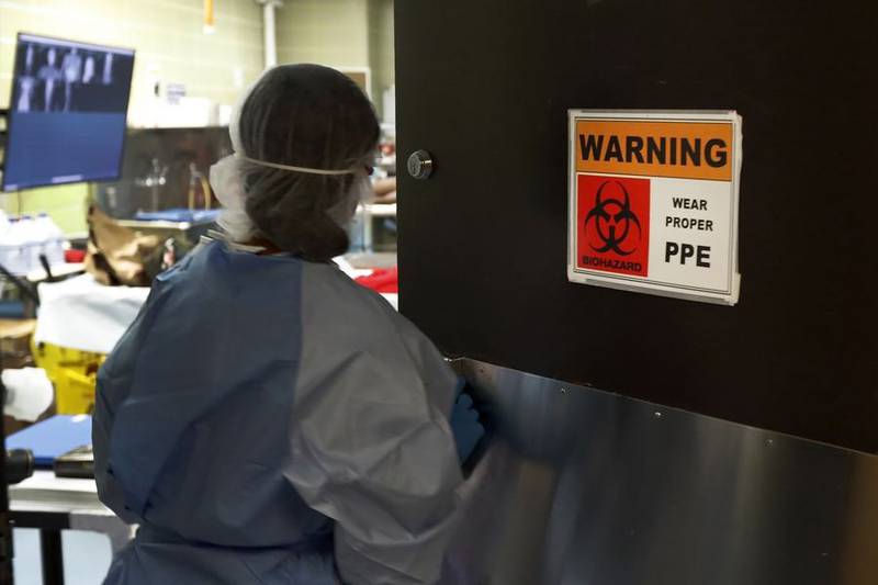 Cook County Chief Medical Examiner Ponni Arunkumar enters an autopsy room at the county morgue as she prepares to perform autopsies last May. Illinois saw a marked decline in COVID-19 deaths per capita in 2021, according to the Centers for Disease Control and Prevention.