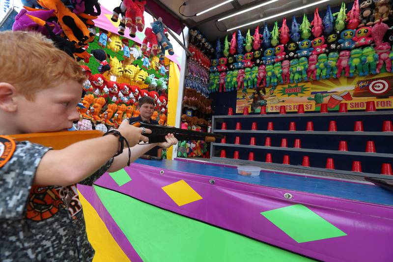 Cody Emmett of Peru, shoots plastic cups at the Shoot Cork Gun Fun stand during the Peru Mall Carnival on Monday, June 26, 2023.