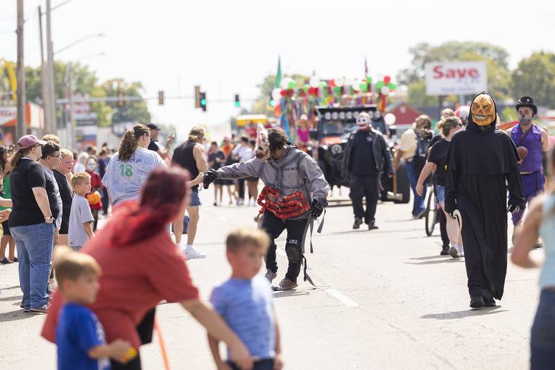 Characters from the Hells Horrors haunted house greet people Saturday, Sept. 14, 2024, along the Fiesta Days parade route.