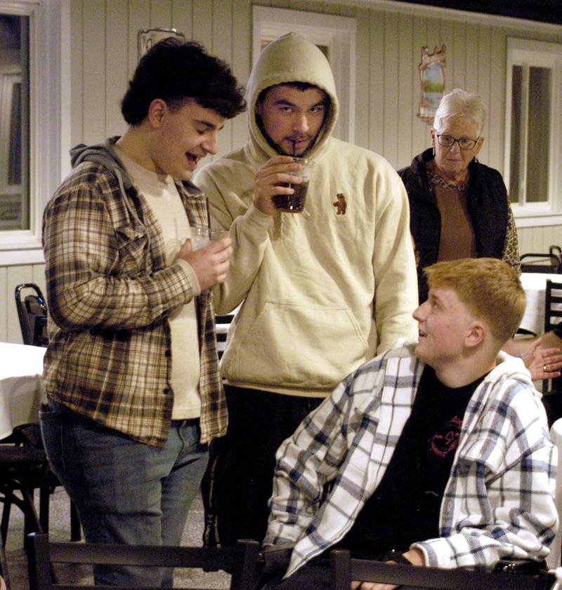 School friends Jacob Drawyer and Issac Duchay talk with Dylan Wescott at his Welcome Home Party at Emerson's Pub in Rock Falls on Saturday, Nov. 22.