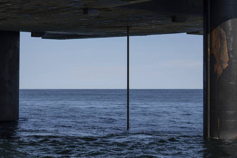 The wireline drilling core barrel is visible from the underside of the Liftboat Robert platform, from the Gaspee, a crew transport vessel, in the North Atlantic, Saturday, July 19, 2025. (AP Photo/Carolyn Kaster)