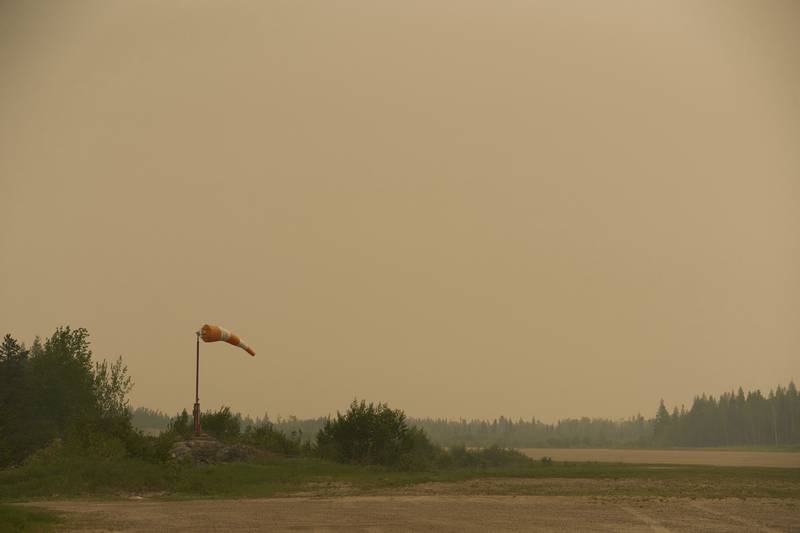Smoke filled skies from out of control wildfires in Norway House, Manitoba Tuesday, June 3, 2025, at the Norway House Airport as crews continue to fight wildfires in northern Manitoba. (David Lipnowski/The Canadian Press via AP)