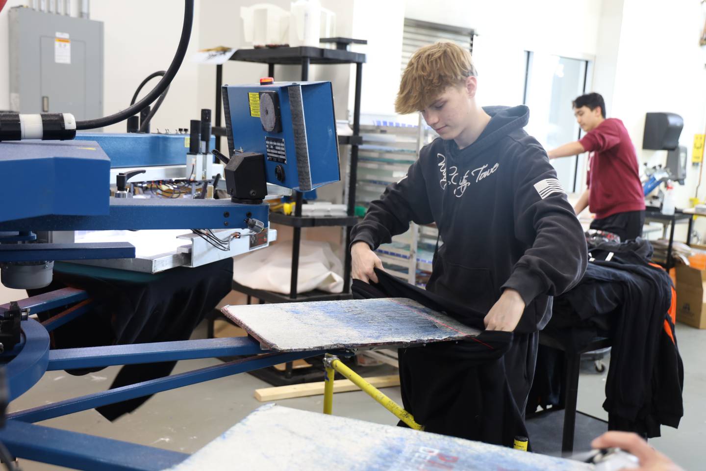 Frankie Piehl works to laminate his project during the advanced graphic communication production class on Tuesday, Oct 29, 2024, at McHenry High School.