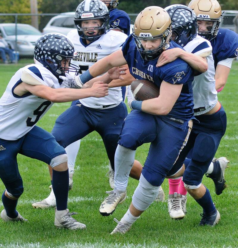 Knoxville’s Austin Harshbarger and Bradley Cummings try to stop Marquette’s Grant Dose as he heads into the end zone to score during the 1st quarter Saturday at Marquette.