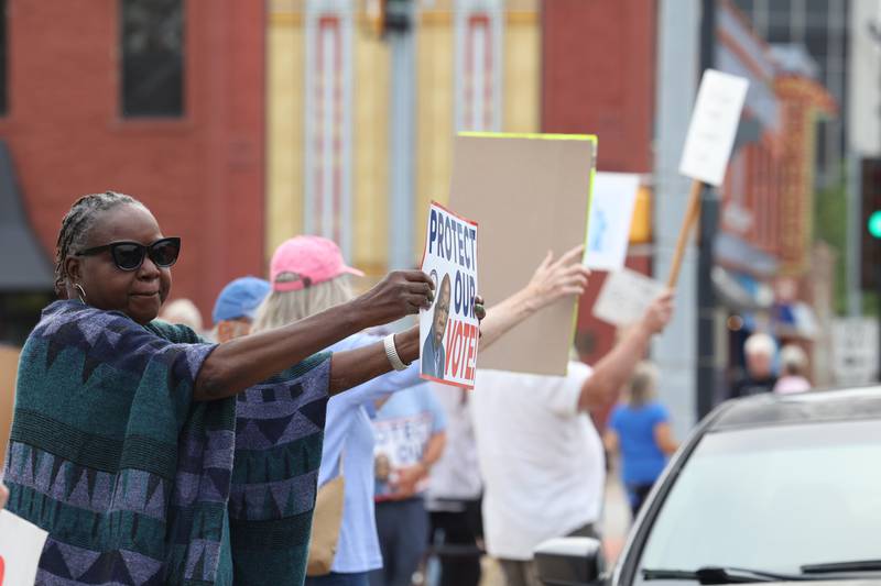 Protesters hold signs along East Court Street  during a "Good Trouble Lives On" rally held in Kankakee as part of a national day of peaceful protests on Thursday, July 17, 2025.