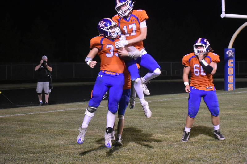 Genoa-Kingston running back Owen Zaccard (33) celebrates his touchdown with Blake Ides (17) and Carson Charnstrom (66) in the Cogs' 56-38 win over North Boone on Friday, Sept. 26, 2025, in Genoa.