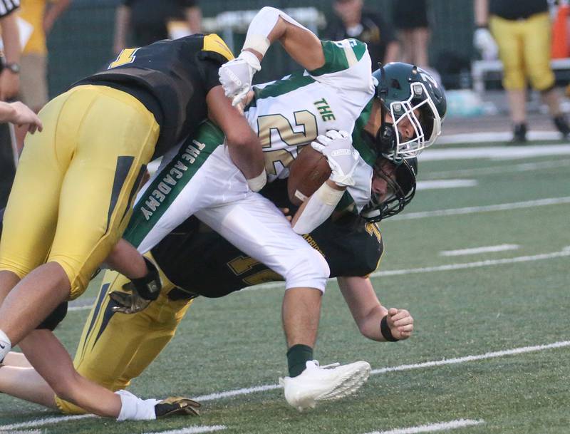St. Bede's Jose DeLaTorre is brought down by a couple of Tuscola players on Friday, Aug. 25, 2023 at Tucci Stadium  in Bloomington.