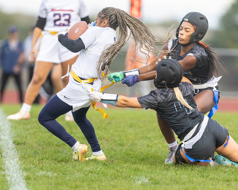 West Aurora's Aiyanah Sylvester has her flags pulled by Willowbrook's Lily Macias(4) and Janell Adams (8) at the Sectional Final on Tuesday, Oct. 14,2025 in South Elgin.