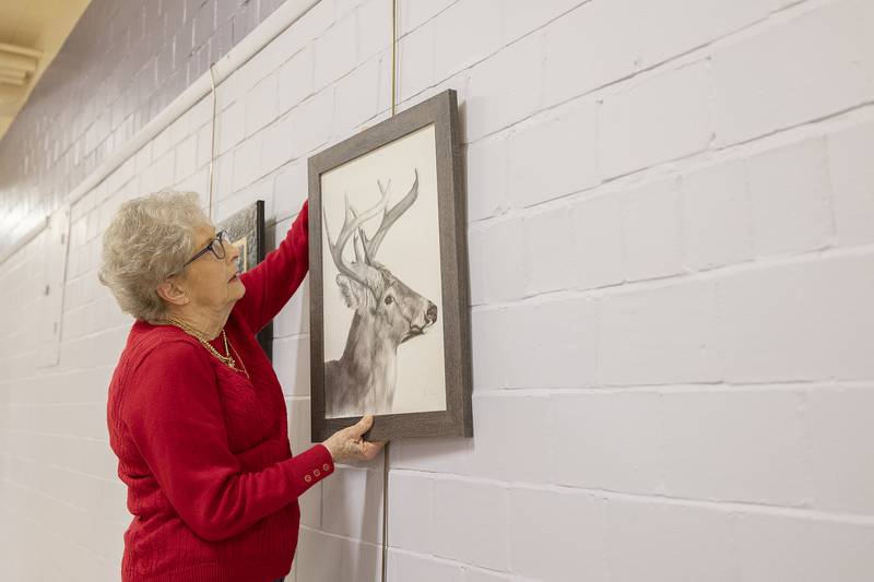 Phidian Art Club member Jan Landreth of Dixon hangs a work Monday, March 31, 2025 at the Loveland House to be included in the 2025 show.