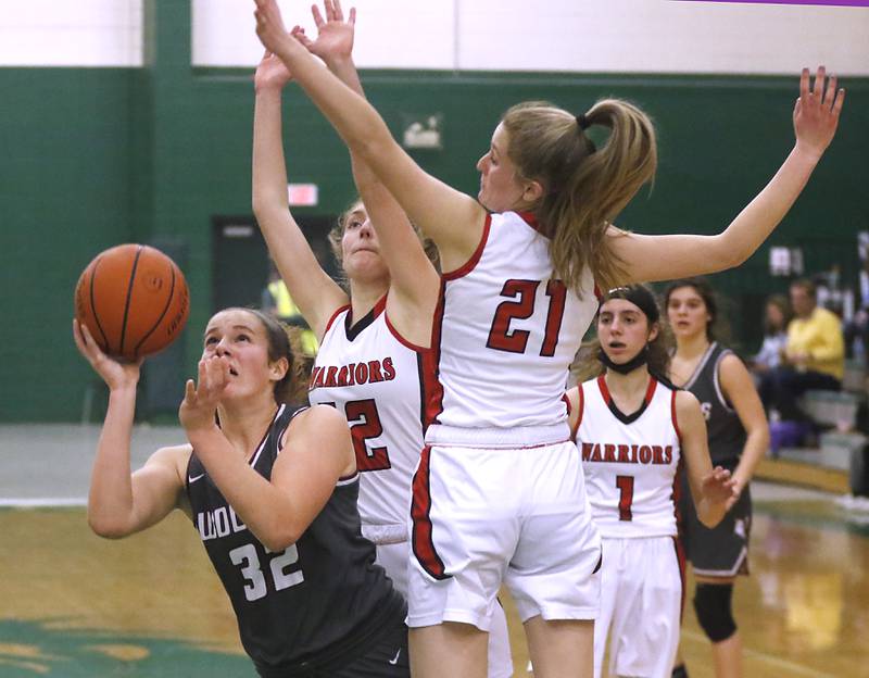 Prairie Ridge's Kelly Gende shoots the ball between the defense of Deerfield's Kate Trella, center and Olivia Trella, left, during a IHSA Class 3A Grayslake Central Sectional semifinal basketball game Tuesday evening, Feb. 22, 2022, between Prairie Ridge and Deerfield at Grayslake Central High School.