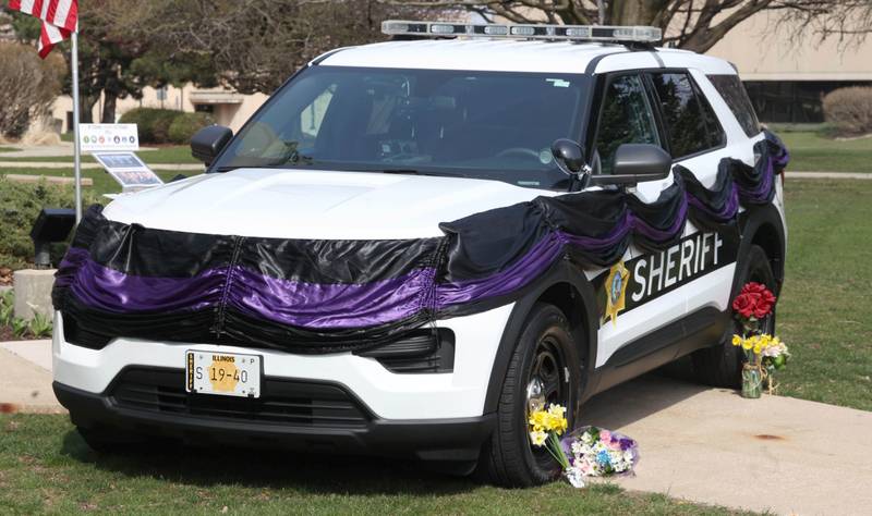 A DeKalb County Sheriff’s vehicle with black and purple bunting sits in front of the DeKalb County Courthouse in Sycamore Friday, March 29, 2024, as a memorial to DeKalb County Sheriff’s Deputy Christina Musil, 35, who died in a crash while working a shift Thursday night.
