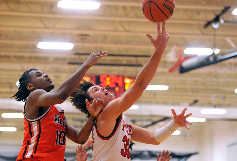 Yorkville's Bryce Salek makes a breakaway layup and get the foul by Romeoville defender Aaron Brown (10) during a boys' basketball game at Yorkville High School on Tuesday, Jan. 10, 2023.