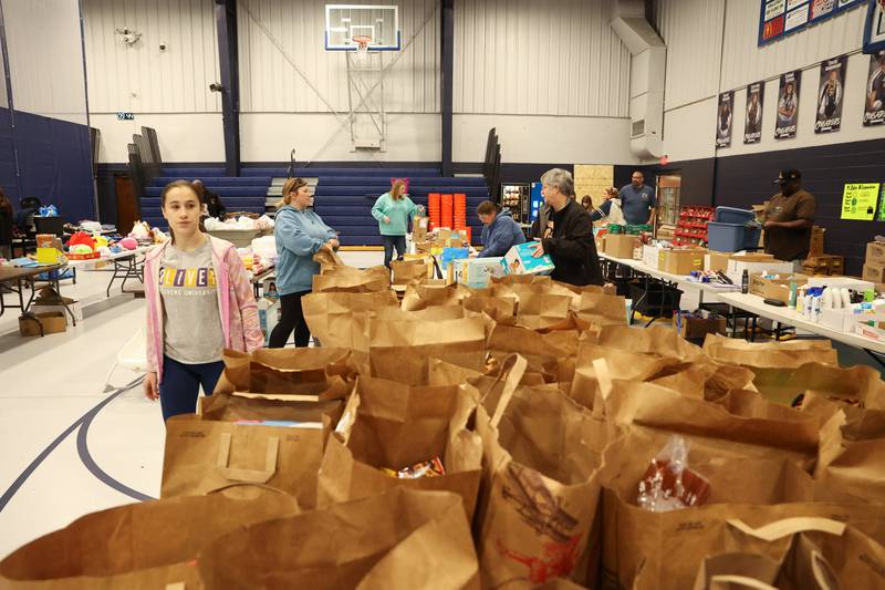 Volunteers prepare grab bags of food and supplies at Grace Christian Academy on Thursday, March 12, 2026, following the EF-3 tornado that tore through Kankakee County on March 10. The school, which is on the outskirts of Aroma Township along Waldron Road, canceled classes in order to become a supply and meal hub for those impacted by the storm.