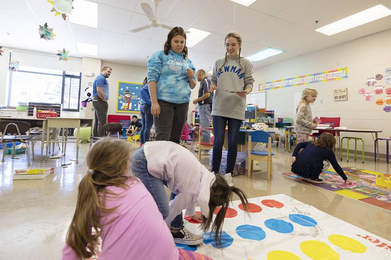 Newman Central Catholic High School juniors Sophia Knudson (left) and Emily Beattie run an exciting game of Twister for kindergartners at St. Mary’s School in Sterling on Thursday, Feb. 2, 2023.
