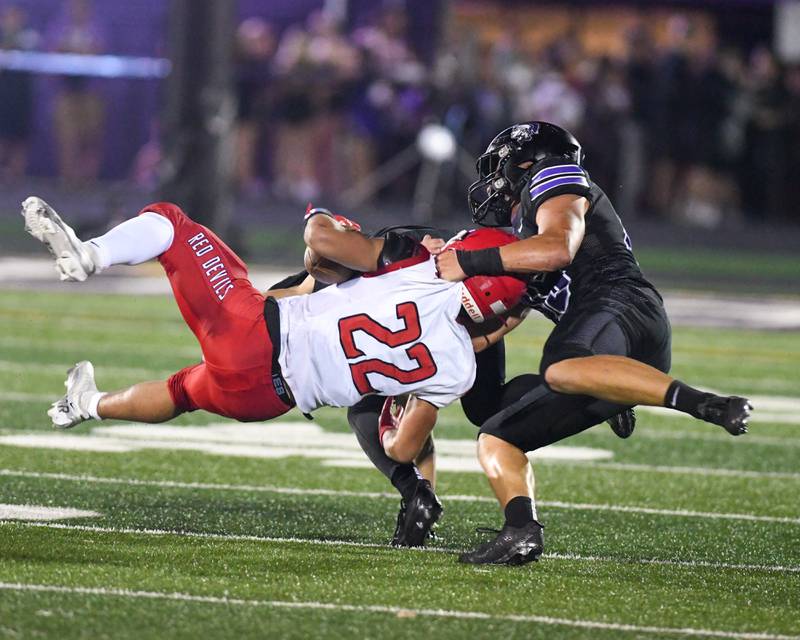 Hinsdale Central’s ball carrier Dominic Tresslar (22) was brought down by Downers Grove North's Rhys Domiow Rhys Dominow (45) during the game on Friday Sept. 12, 2025, held at Downers Grove North High School.