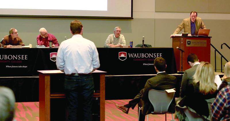 Dan Olsem (far right) from Crown Development answers a question from Sugar Grove resident Tim Balles Feb. 6 at Waubonsee Community College in Sugar Grove.
