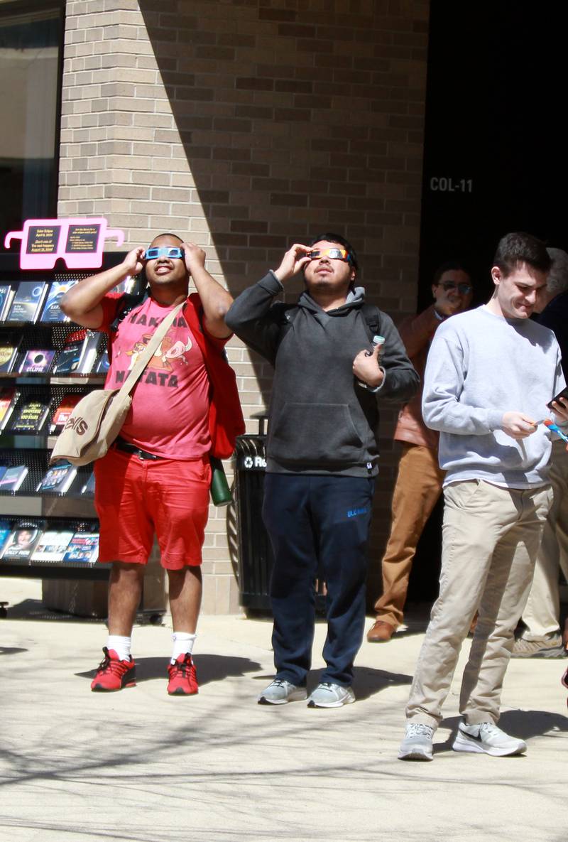 Waubonsee Community College students and faculty look at the sun using special protective glasses during the solar eclipse on Monday, April 8, 2024 at the college’s Sugar Grove campus.