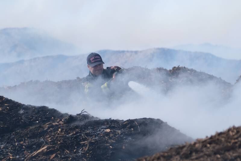 A New Lenox firefighter waters down piles of smoldering mulch at 815 Mulch It in New Lenox. Monday, Jan. 31, 2022 in New Lenox.