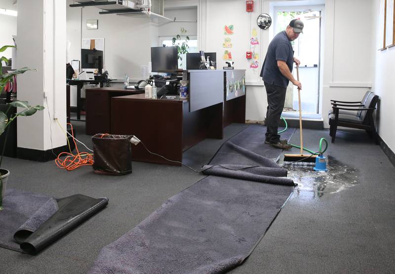 Jason Orabutt with Town and Country Services, pushes standing water into a pump inside the basement of the Bureau County Courthouse on Friday, July 11, 2025 in Princeton. Princeton received over 4 inches of rain from the storm system that sent winds and heavy precipitation to the area.