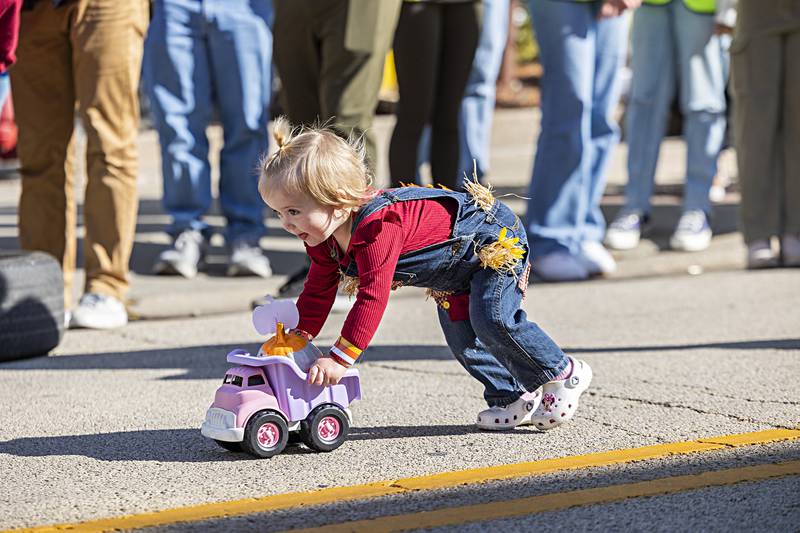 What should be all gravity power, Trasyn Call, 2, of Sterling makes up her own rules during the pumpkin derby at Dixon’s Scarecrow Fest Saturday, Oct. 21, 2023. Competitors built or modified shuttles for their pumpkin rides and raced them on Hennepin Avenue downtown.