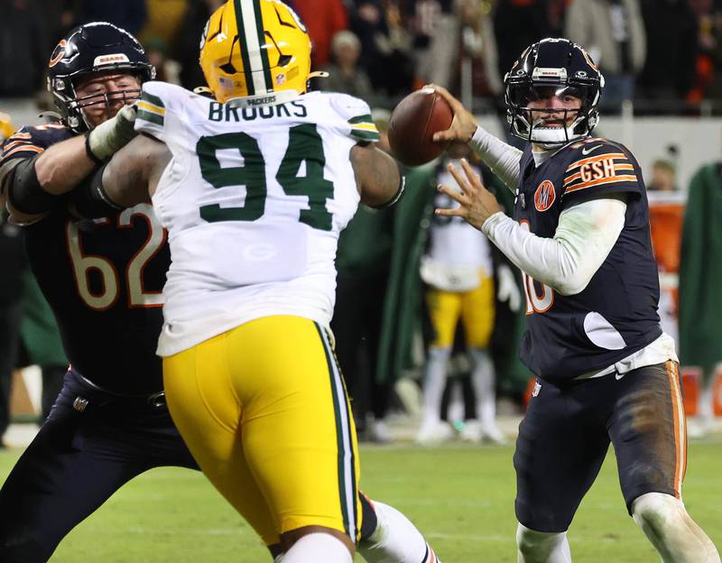 Chicago Bears quarterback Caleb Williams throws a pass as guard Joe Thuney blocks Green Bay Packers defensive end Karl Brooks during their NFL Wild Card game Saturday, Jan. 10, 2026, at Soldier Field in Chicago.