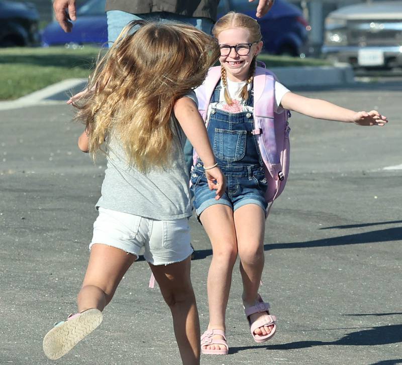 Second-graders and good friends Addison Craft (left) and Aubrey Crawford run for a hug after spotting each other Wednesday, Aug. 17, 2022, on the first day of school at North Elementary in Sycamore.