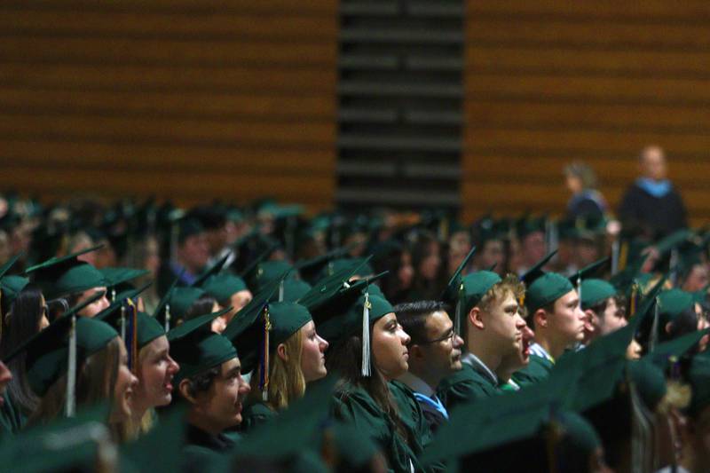 Members of the Class of 2024 watch the senior class video before York High School’s graduation at the school in Elmhurst on Sunday.