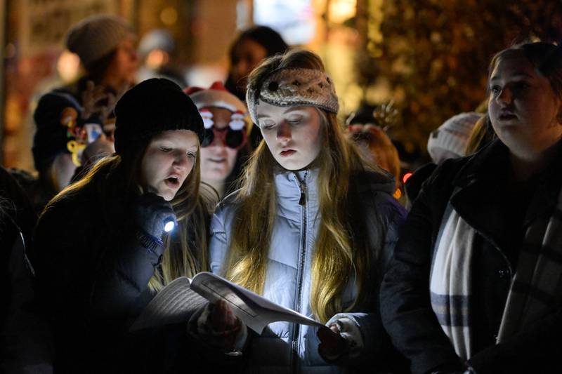 Kourtiney Parsons and Jaclyn Eakins from St. Charles East sing carols as part of the Lighting of the Lights Ceremony at 1st Street Plaza on Friday, Nov 28, 2025 in St. Charles.