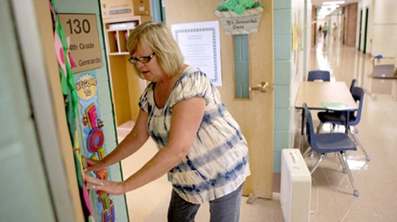 Fourth grade teacher Barb Gennardo decorates the outside of her classroom at Fox Ridge Elementary School in St. Charles on Tuesday afternoon. The Consumer Price Index is higher than last year, which means more breathing room for school district budgets and slightly higher taxes for property owners.