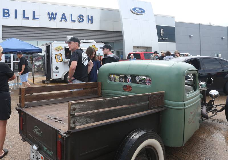 Bill Walsh junior (center) chats with visitors during the Cars and Coffee Car Show on Sunday,  July 14, 2024 at Bill Walsh Kia and Ford in Ottawa.