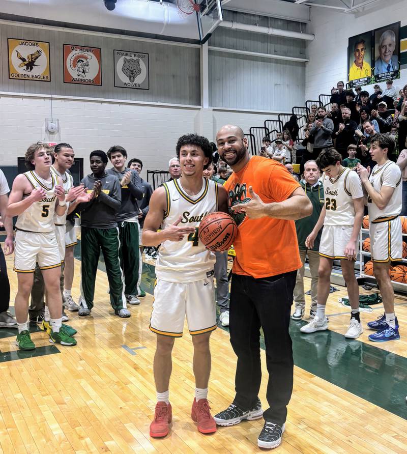 Crystal Lake South's AJ Demirov (left) poses for a picture with Phil Wallace after the senior guard broke Wallace's boys basketball scoring record Friday, Feb. 14, 2025, against visiting Crystal Lake Central.