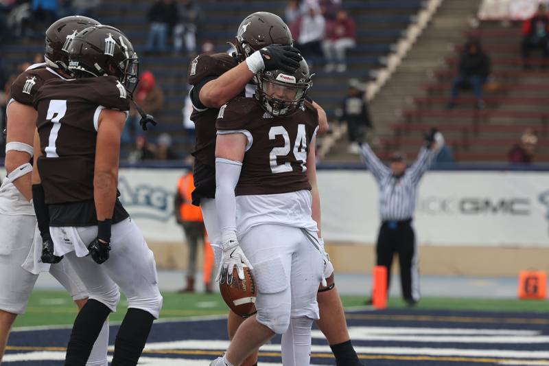 Joliet Catholic’s Larry Stringham is greeted by teammate after a touchdown run against Morris in the Class 5A semifinal on Saturday, Nov. 23, 2024.