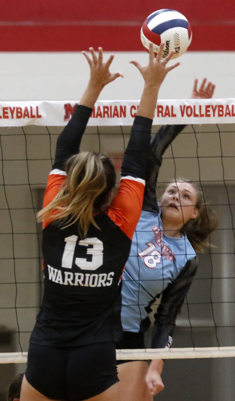 Marian Central's Ella Conlon tries to hit through the block of McHenry's Alissa Ricci during a nonconference volleyball match Monday, Aug. 28, 2023, at Marian Central Catholic High School.