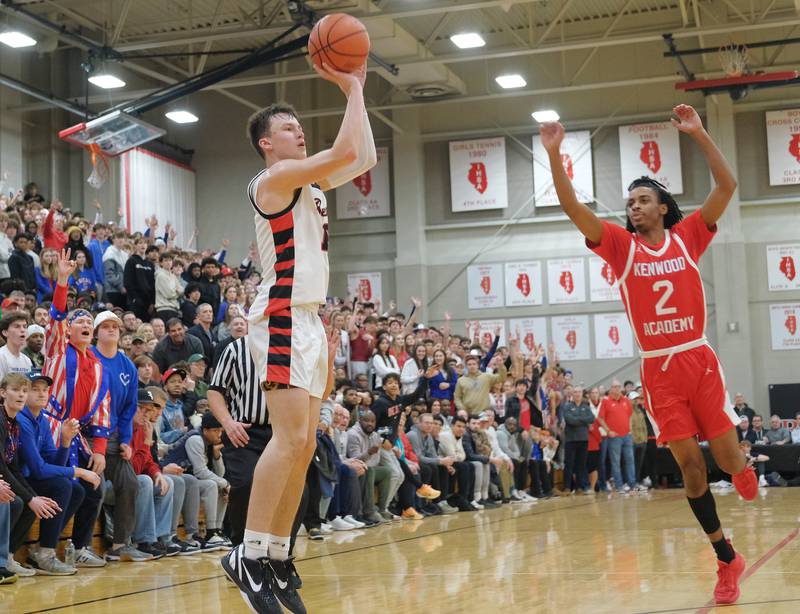 Benet’s Andy Nash shoots a crucial fourth quarter three pointer as Kenwood's Tyler Smith arrives late near the end of a "When Sides Collide" invitational game on Jan. 21, 2023 at Benet Academy in Lisle.