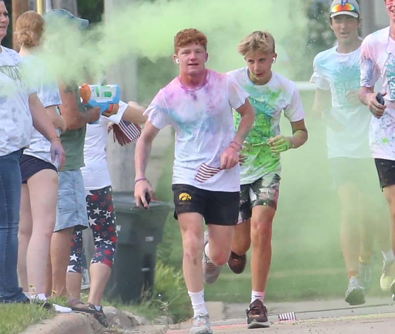 Halk Amy, Brice Brant and Logan Walters jog through green colored chalk during the Arukah Institute of Healing Freedom Color Run on Friday, July 4, 2025 at Soldiers and Sailors Park in Princeton.