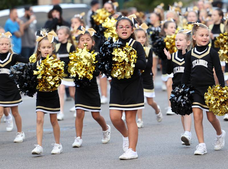 The Sycamore Junior Spartans cheerleaders march through downtown Sycamore Wednesday, Oct. 5, 2022, during the high school's homecoming parade.
