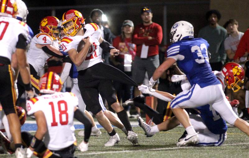 Batavia quarterback Ryan Boe keeps the ball as he tangles with the Geneva defense during a game at Geneva on Friday, Sept. 29, 2023.