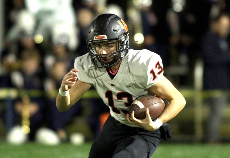 Libertyville’s Luka Nikolich looks for running room in first-round Class 6A playoff  football action at Cary Friday.