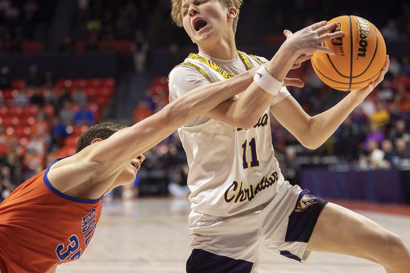 Peoria Christian’s Myles Zimmerman scoops up a ball as Eastland’s Parker Krogman reaches for it Thursday, March 13, 2025, during the Class 1A boys basketball state semifinal.